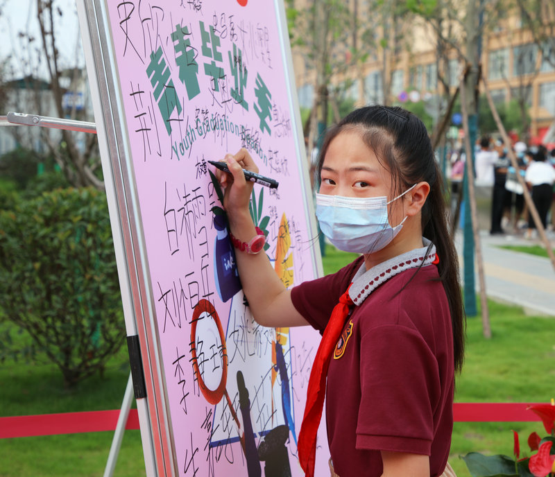 3、學生在簽名墻上簽字.jpg